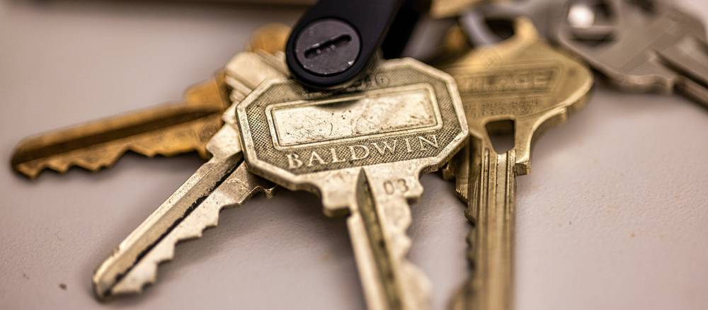 Tenant hands apartment keys to landlord after early lease termination in Michigan
