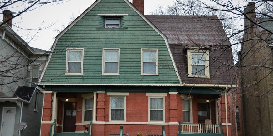 Prospective renters discuss lease terms while reviewing a Michigan fair-housing brochure