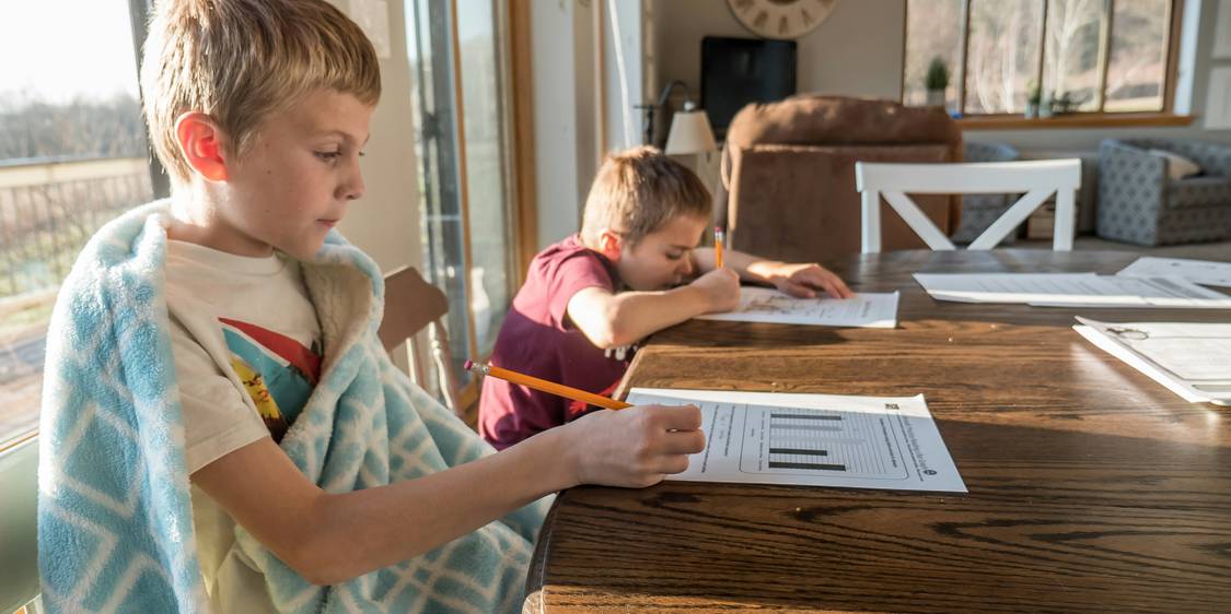Family reviews rental-assistance paperwork at a kitchen table in Michigan