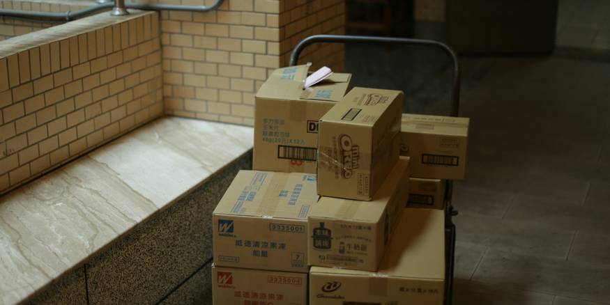 Moving boxes stacked in a bright apartment foyer during daylight