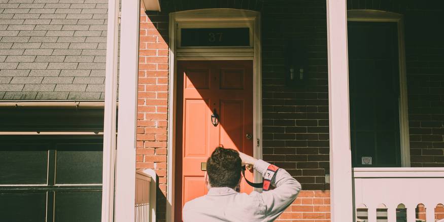 Young renter reviewing a Michigan lease on the porch of a Detroit duplex