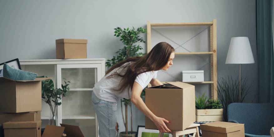 Renter reviews itemized deduction list while surrounded by packed boxes